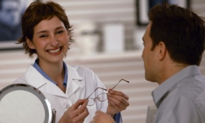woman w/ glasses checking man's eyes
