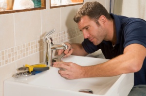 man fixing sink