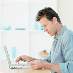 man sitting by laptop